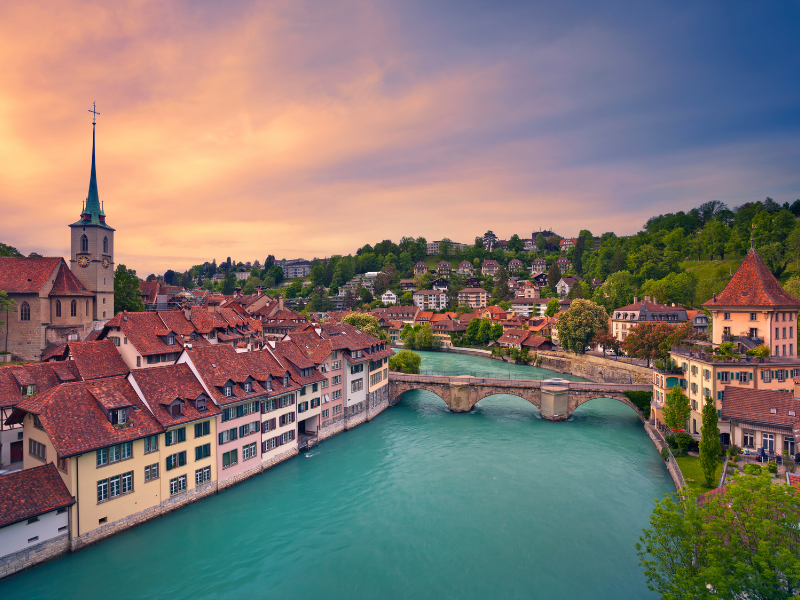 Erotische Massage Bern - Blick auf die Altstadt von Bern mit dem Fluss Aare und einer historischen Brücke bei Sonnenuntergang