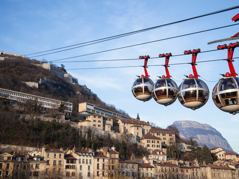 Massage érotique Grenoble - Téléphérique à Grenoble avec vue sur la montagne et la ville en arrière-plan