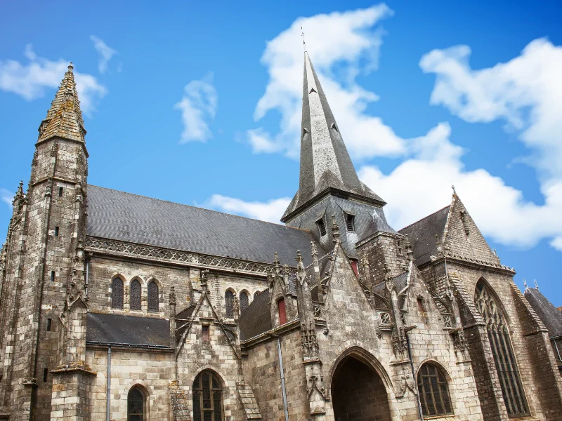 Massage érotique Saint-Herblain - Église historique à Saint-Herblain sous un ciel bleu avec des nuages