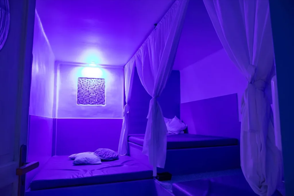 Salle privée d un club libertin avec lits bas et rideaux clairs