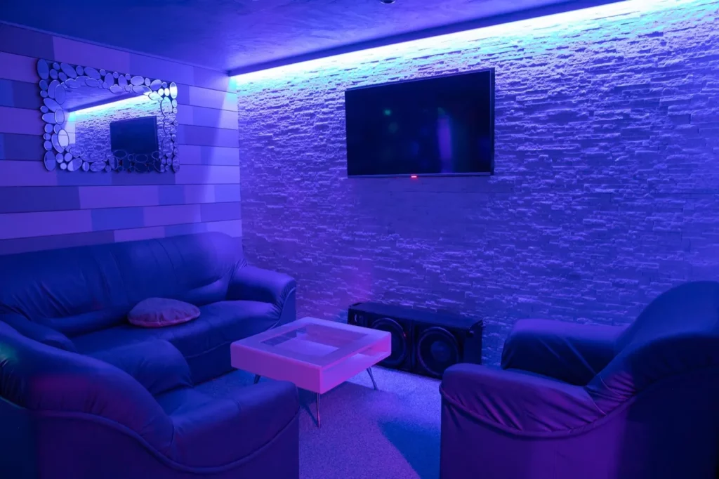 Salon d un club échangiste d Aix-les-Bains, canapés et éclairage bleuté