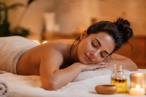 Femme détendue sur une table de massage, à la lueur des bougies