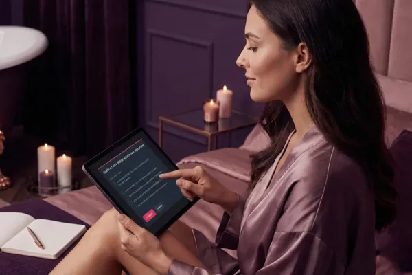 Femme en déshabillé qui répond à un sondage sur une tablette